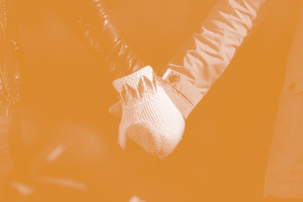 Students holding hands while wearing mittens.