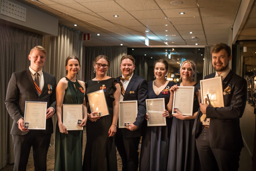 Paikan päällä ansiomerkkinsä vastaanottamassa (vas.) Henri Mella, Julia Rapo, Hanna Palosuo, Jere Tapio, Elina Kuula, Katariina Henttonen ja Samuli Valkama.